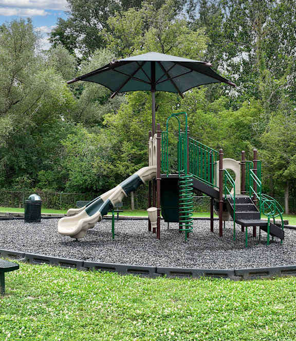 A playground with a green slide and a brown slide.