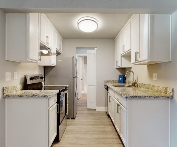 a kitchen with white cabinets and granite countertops