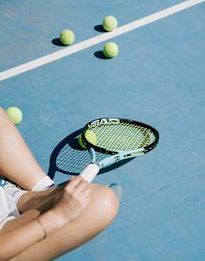 Tennis ball and racket on a blue court.