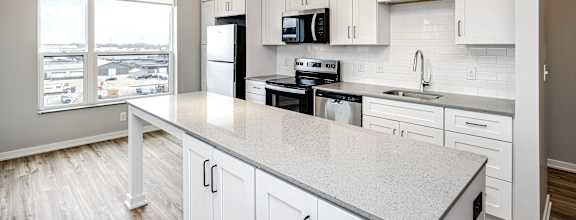 A kitchen with white cabinets and a large island.