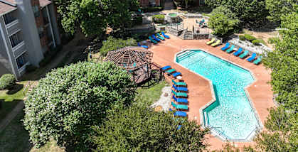 an aerial view of a resort style swimming pool with lounge chairs at Foxborough Apartments, Irving, TX