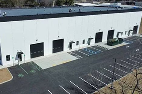 an aerial view of a white building with a parking lot