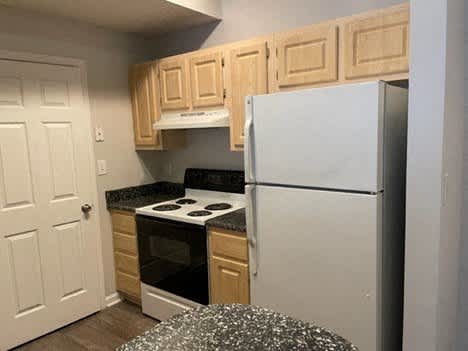 a kitchen with a refrigerator and a stove and cabinets
