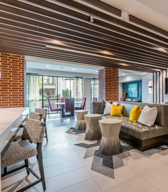 A modern living room with a brick wall and a wooden ceiling.