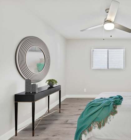 A bedroom with a bed, a dresser, and a mirror.