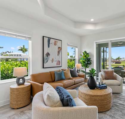 A well-lit living room with a large window and a view of a green lawn.