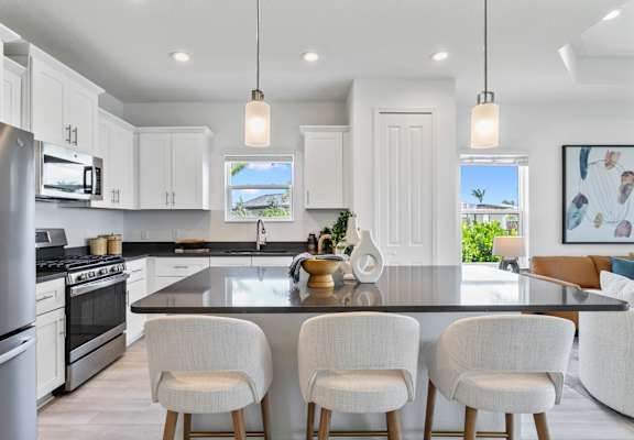 A modern kitchen with white cabinets and a black countertop.