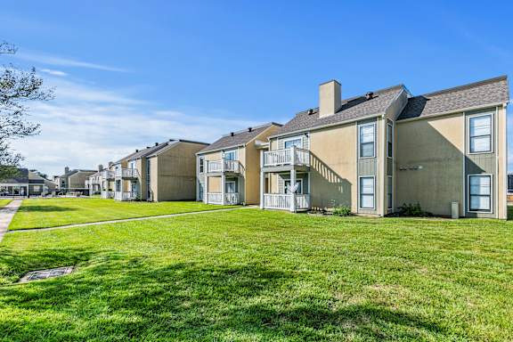 A row of houses with green lawns in front.