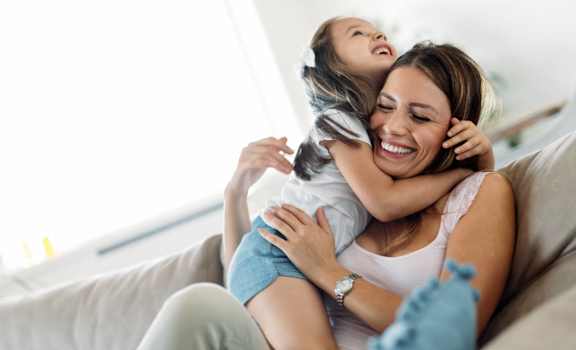 a woman sitting on a couch with a child on her back