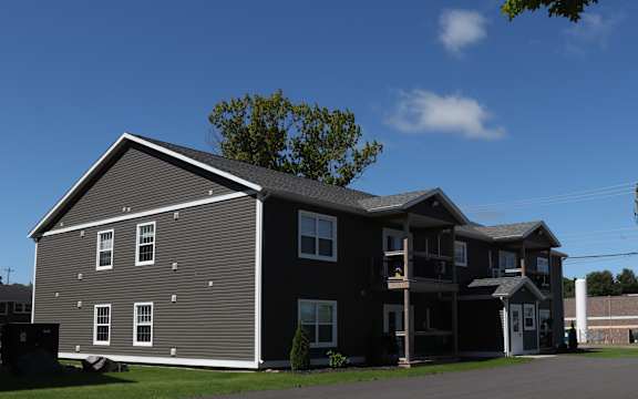 a gray house with a gray roof and a blue sky
