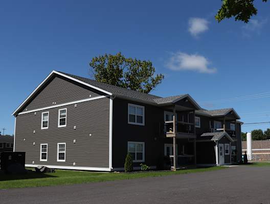 a gray house with a gray roof and a blue sky