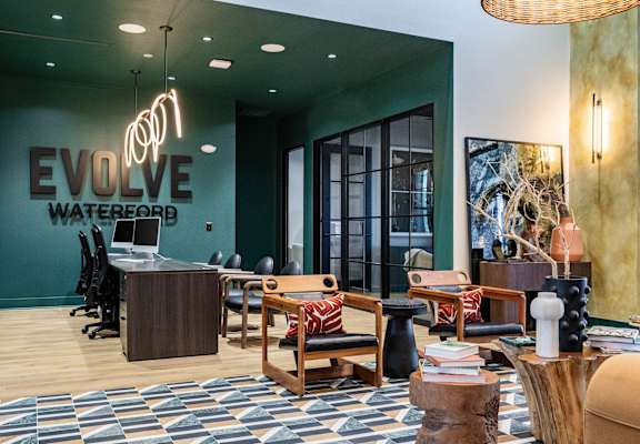 A modern office space with a green wall and a sign that reads "Evolve Waterboard".