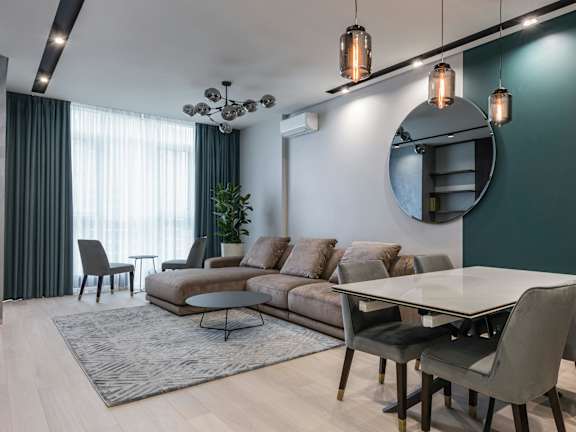 A living room with white furniture and a chandelier.