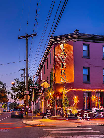 A street view of a city with a building that has a sign that says "TAVERN".