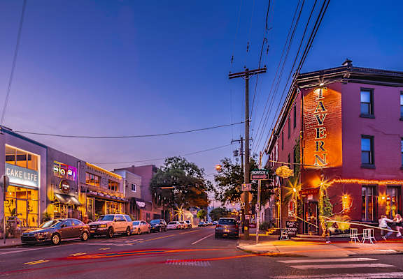 A street view of a city with a building that has a sign that says "TAVERN".