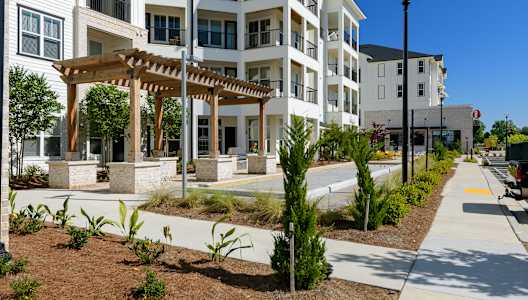 an exterior view of an apartment building with a walkway and sidewalk at The Eddy at Riverview, Georgia