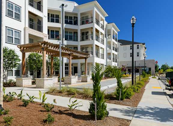 an exterior view of an apartment building with a walkway and sidewalk