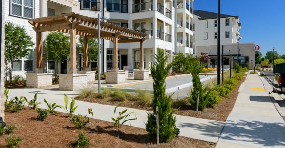 an exterior view of an apartment building with a walkway and sidewalk at The Eddy at Riverview, Georgia