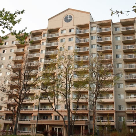 a large apartment building with trees in front of it