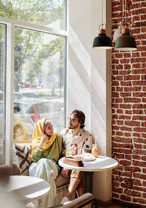 Couple sitting by a window at a cafe
