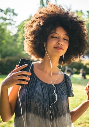 Woman listening headphones in the park