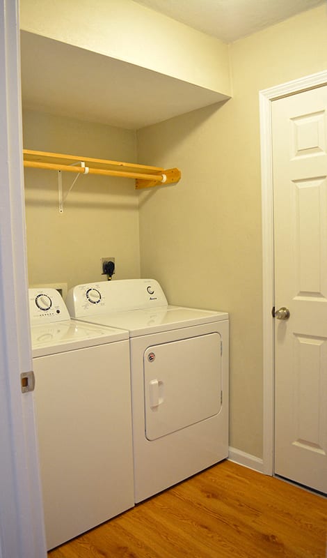 In-unit laundry room with full-size washer and dryer and hanging rack