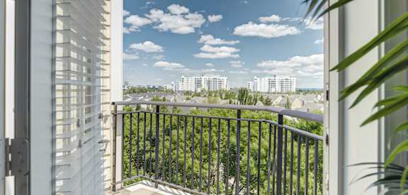 a balcony with a view of a city and a blue sky