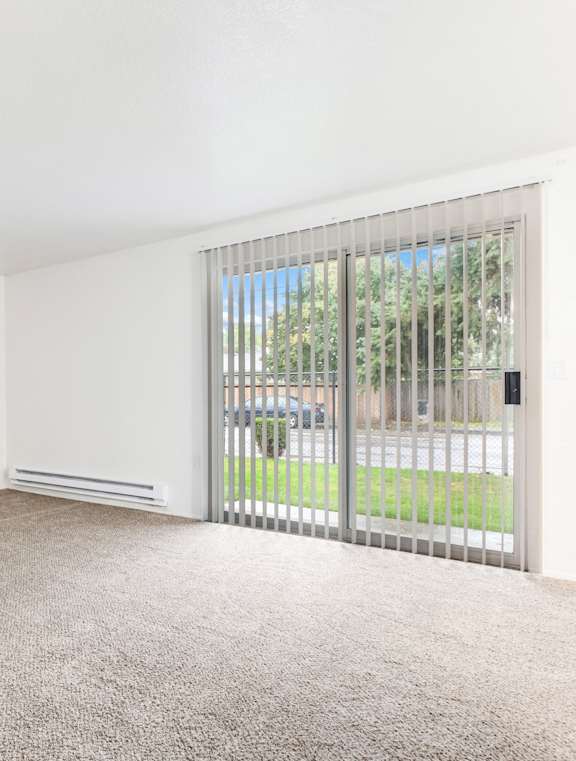 A room with a carpeted floor and a sliding glass door.