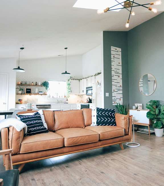 A living room with a brown sofa and a grey armchair.