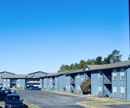 A parking lot with cars and apartment buildings in the background.