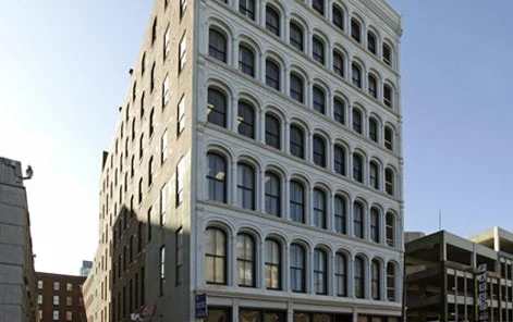 A tall building with many windows is in the foreground.