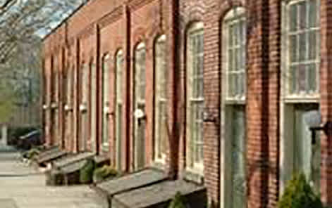 A long building with many windows and benches outside.
