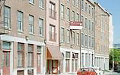 A red car is parked on the side of a street.