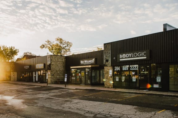 the exterior of a store with the sun shining on the street
