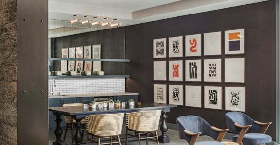 A modern dining room with a long table and chairs.
