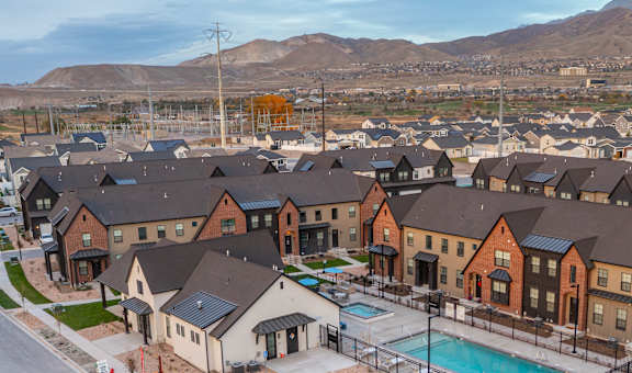 A large housing complex with a pool and tennis court.