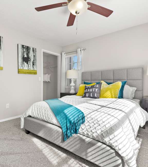 A bedroom with a bed, nightstand, and two framed pictures on the wall.