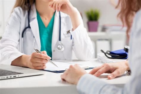 A doctor is writing on a clipboard while consulting with a patient. at Palma, Florida