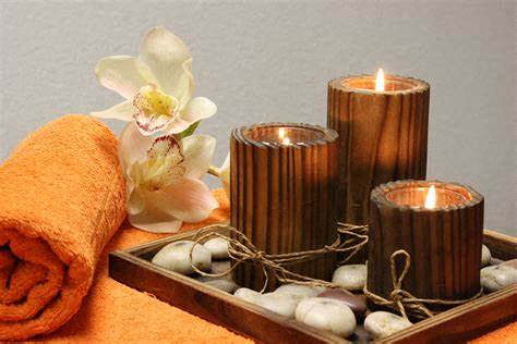 a tray with candles and a towel and a flower