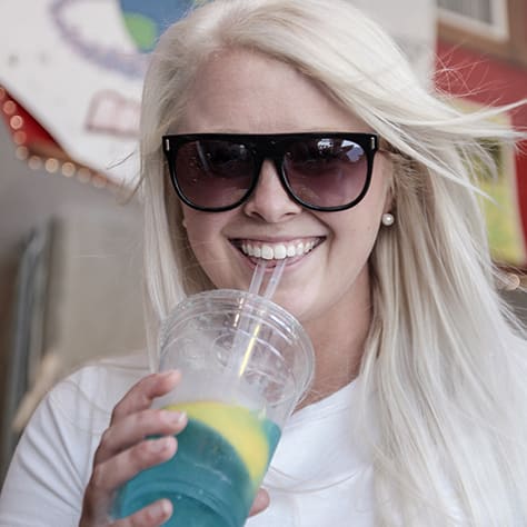 A women sipping blue lemonade.