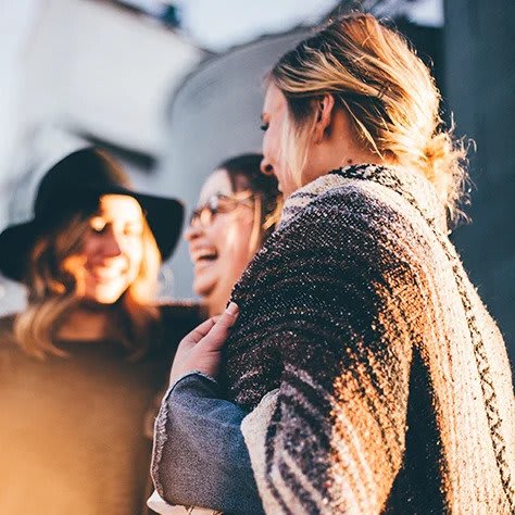 A group of girlfriends laughing amonst one another.
