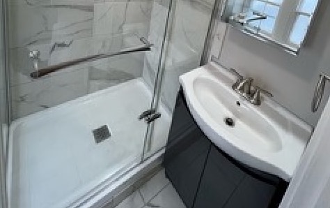 a bathroom with a shower sink and mirror