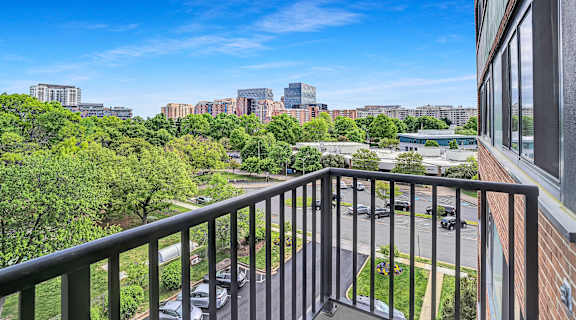 the view of the city from the balcony of a hotel room with a balcony railing