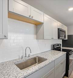 A kitchen with a sink, microwave, and oven.at Palisades Apartments, Missouri