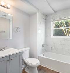 A white bathroom with a toilet, sink, and bathtub.at Palisades Apartments, Missouri, 64133