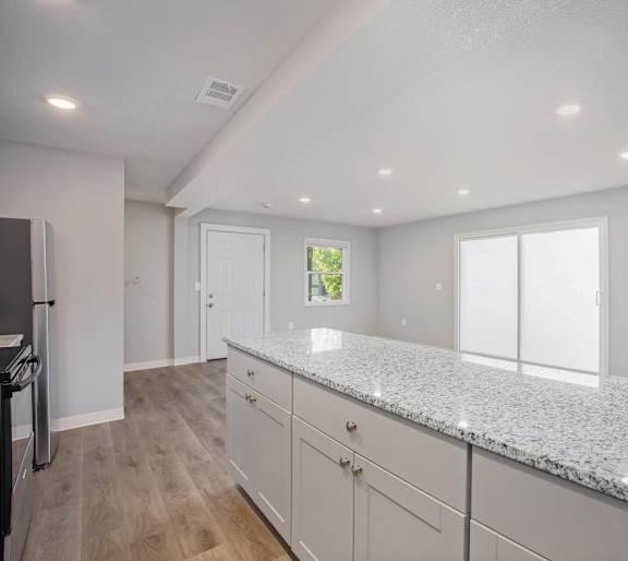 A kitchen with granite countertops and white cabinets.at Palisades Apartments, Kansas City Missouri