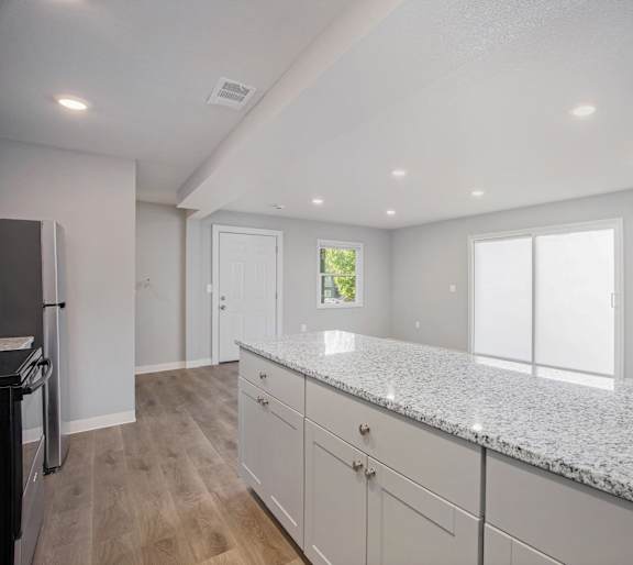 A kitchen with granite countertops and white cabinets.at Palisades Apartments, Kansas City Missouri