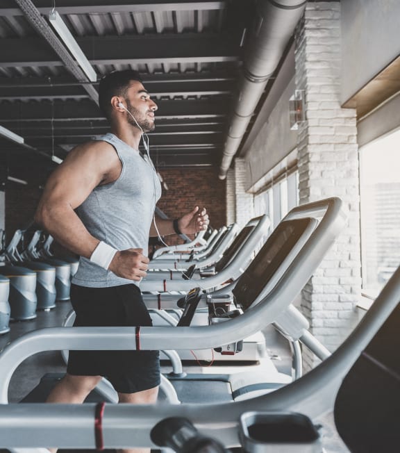 a man running on a treadmill in a gym