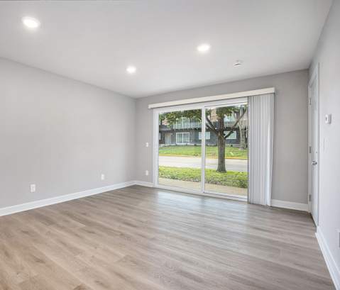 A room with a sliding glass door leading to a backyard.at Palisades Apartments, Kansas City, MO