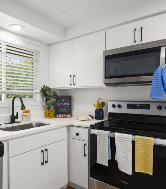 a kitchen with white cabinets and black appliances